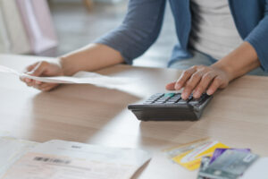 Close up businessman hand calculating monthly expense and credit card debt.